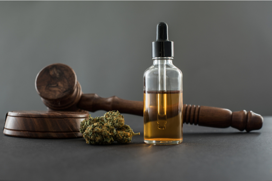 CBD oil and dried cannabis sit next to a judges' gavel
